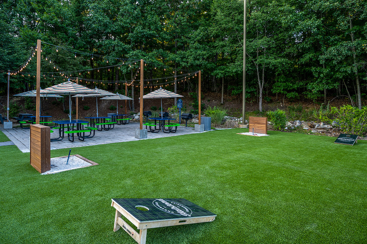 a spacious community yard with corn hole and horseshoe games