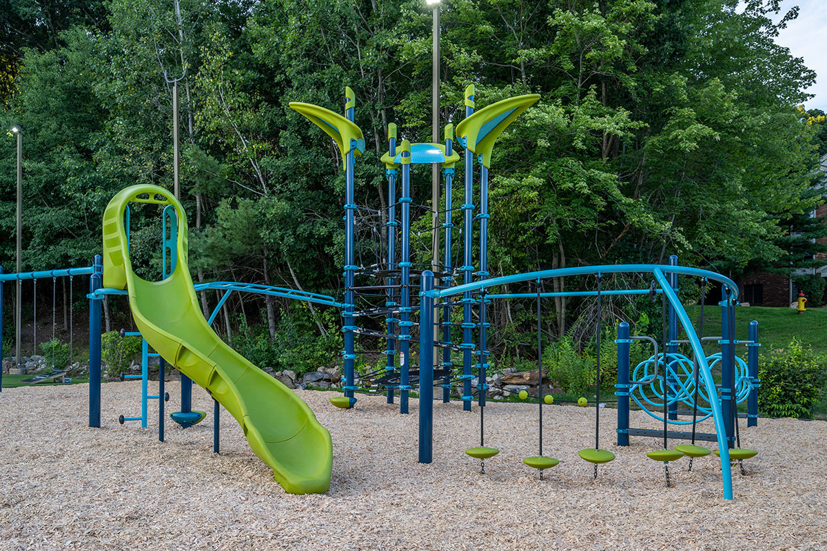 a huge outdoor playground for kids with a blue jungle gym