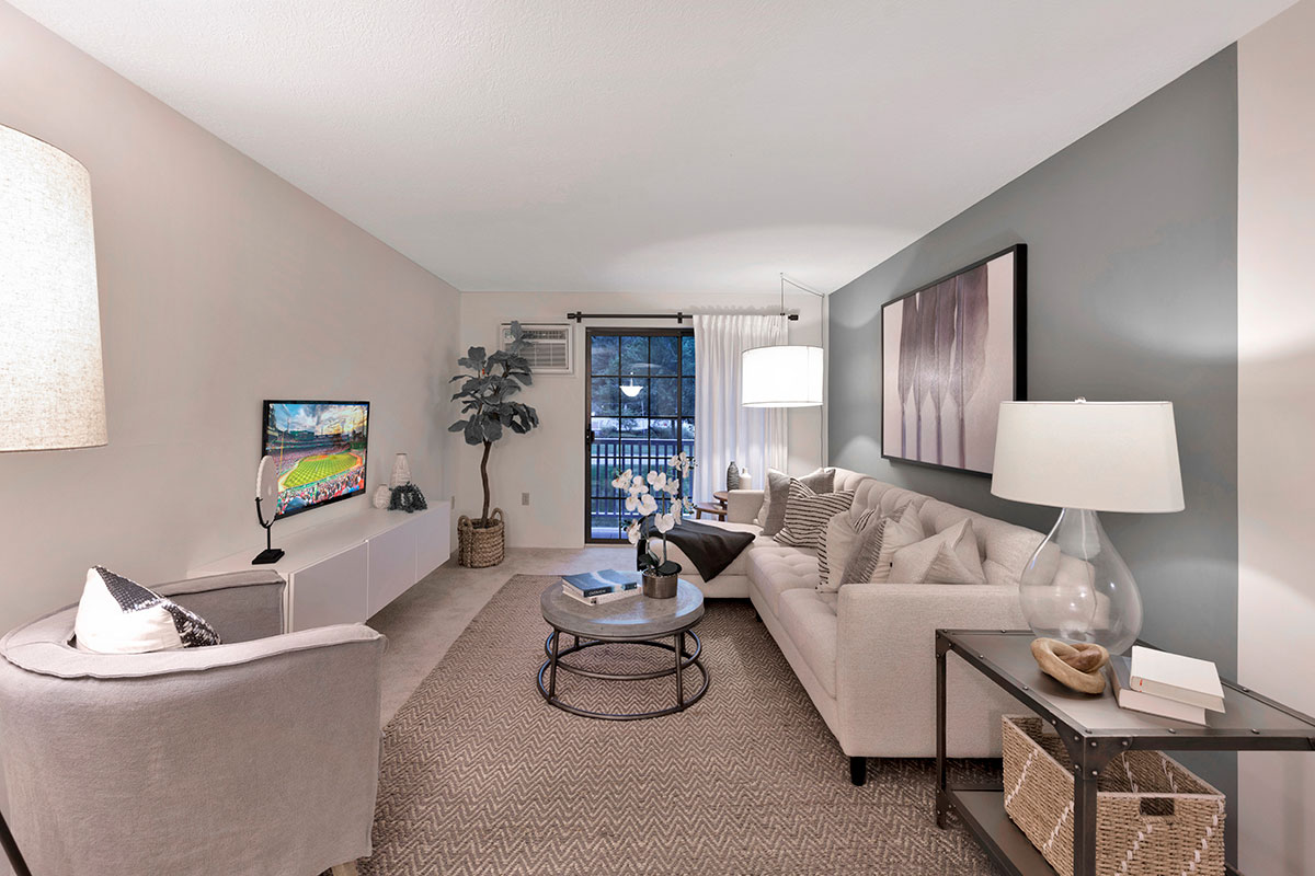 a spacious apartment living room with taupe colored furniture